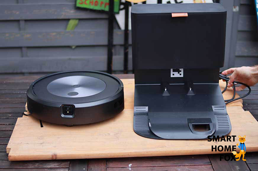 iRobot Roomba j7 стоит на столе вместе со своей станцией самоочистки